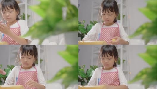 亚洲女孩用饼干切割机塑造自制饼干庆祝圣诞节，生活理念。高清在线视频素材下载
