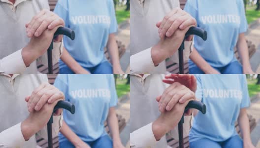 女志愿者抚摸病人的手，支持老人，陪伴高清在线视频素材下载