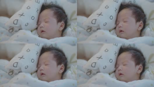 可爱的亚洲新生儿睡在床上。高清在线视频素材下载