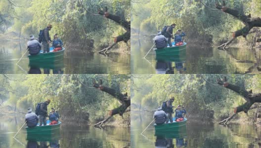 森林中，一对情侣在湖中划着小船，欣赏风景和拍照高清在线视频素材下载