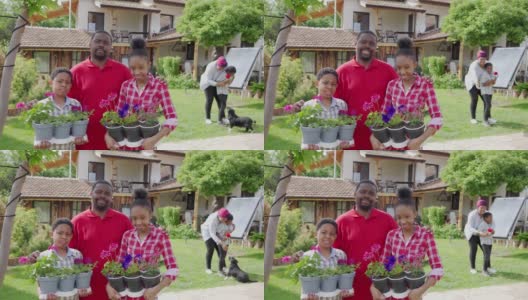 一个微笑的父亲在他的孩子之间，他们拿着花盆里的花高清在线视频素材下载
