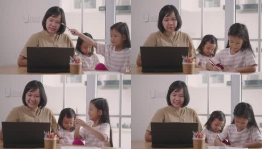亚洲妇女视频通话笔记本电脑，同时照顾她的女儿在家里高清在线视频素材下载