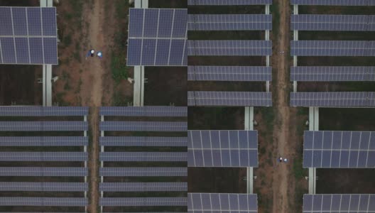 对称太阳能电池板农场的鸟瞰图，生产清洁电力，非常小的工人在中间的小轨道高清在线视频素材下载