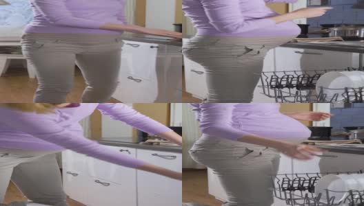 孕妇从洗碗机里拿出干净的盘子高清在线视频素材下载