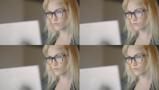 职场女性在办公室使用笔记本电脑时戴眼镜高清在线视频素材下载