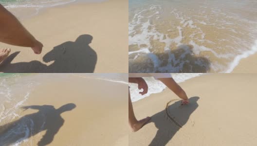 男人在沙滩上画着一颗心，海浪覆盖着一颗心的特写。浪漫的爱情象征在海边。爱，爱，心，画在沙滩上的沙高清在线视频素材下载