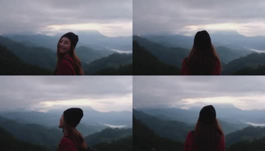 慢动作模糊的后视图，一个女性旅行者看着一个美丽的山景在雾天高清在线视频素材下载