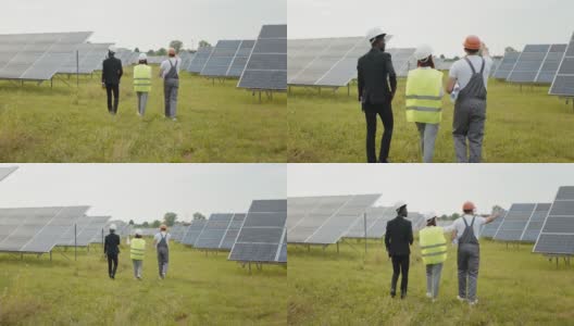两个戴着白色头盔的检查人员和穿着制服的技术人员在太阳能电站上行走的背影。多种族工程师在户外检查光伏电池的工作。工人们在太阳能电站上行走高清在线视频素材下载