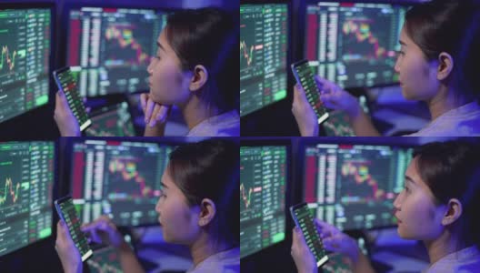 年轻的女商人使用多个电脑屏幕学习和交易加密货币和股票市场和交易所，同时工作到深夜高清在线视频素材下载