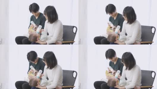亚洲父母正在给双胞胎婴儿喂奶高清在线视频素材下载