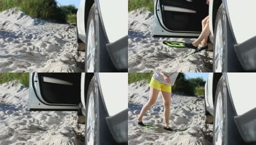 沙滩上，一个穿着拖鞋的女人从车里出来高清在线视频素材下载
