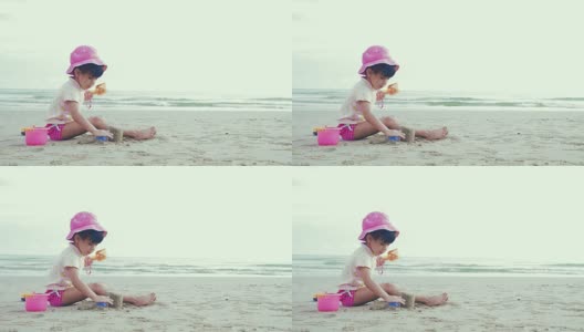 Cinemagraph:可爱的女孩在沙滩上玩沙子和快乐高清在线视频素材下载