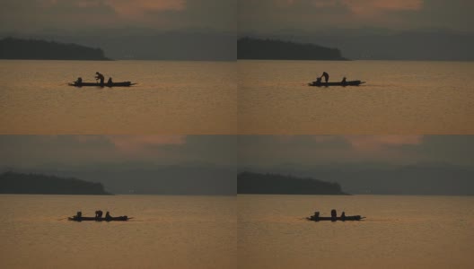 画面:黄昏时分，渔民在大坝上的长船上捕鱼高清在线视频素材下载