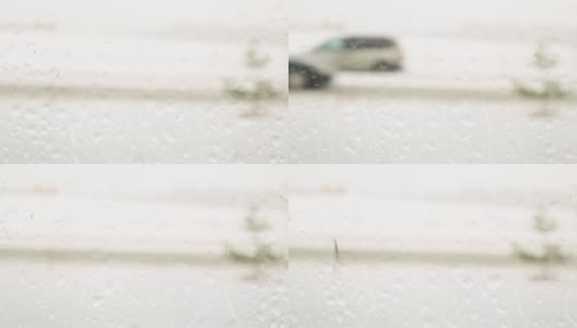 透过玻璃看路。雪正在下降。窗户是湿的。高清在线视频素材下载