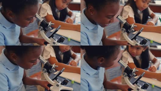 可爱的非裔美国小学生在生物课上使用显微镜高清在线视频素材下载
