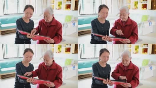 孙女和奶奶坐在一起看老照片。高清在线视频素材下载
