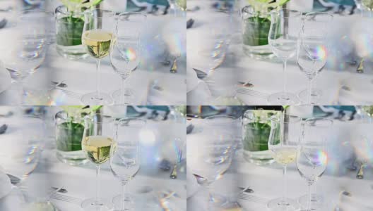 在水晶窗帘后面的精致餐桌上倒白葡萄酒高清在线视频素材下载