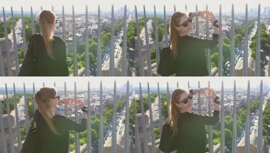 一名女子站在巴黎凯旋门上，双手搭成心形，俯视着整个城市高清在线视频素材下载