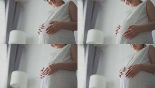 孕妇轻轻抚摸她的肚子高清在线视频素材下载