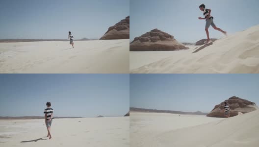 迷人的小男孩跑下沙丘与岩石沙漠慢镜头高清在线视频素材下载