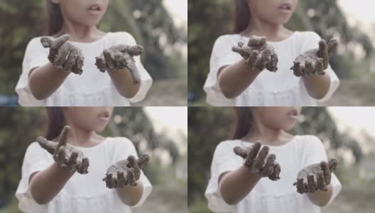 亚洲女孩玩泥巴和显示脏手后种植高清在线视频素材下载