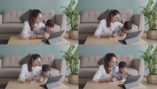 亚洲家庭，女儿在妈妈的帮助下用平板电脑做作业高清在线视频素材下载