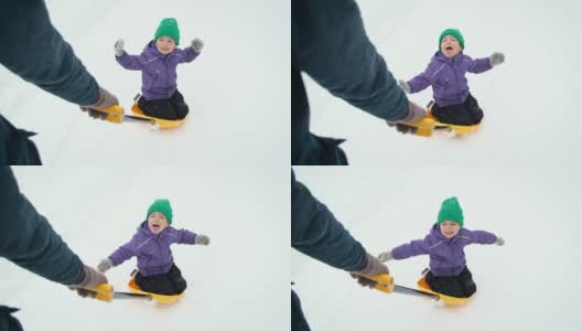在暴风雪中，波夫的父亲骑着他的小孩在乡村公路上铲雪。爸爸和儿子在冬天的户外玩得很开心。高清在线视频素材下载