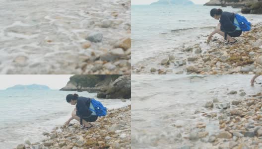 女人在沙滩上玩小石头高清在线视频素材下载