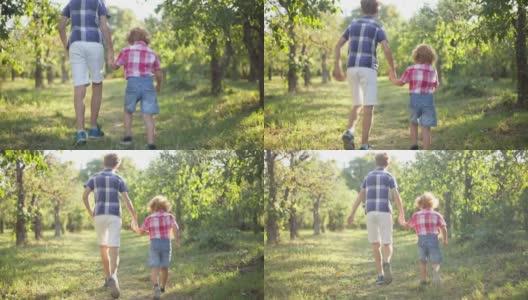 镜头跟随快乐的白人兄弟在阳光下奔跑在夏季春天的户外公园。在阳光明媚的日子里，孩子们手牵着手在户外玩耍。高清在线视频素材下载