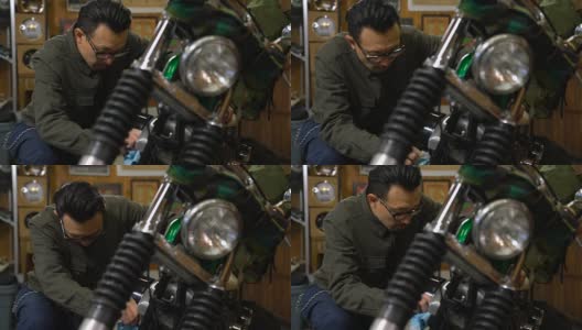 一个男人在他的车库里打磨和维护他的定制摩托车高清在线视频素材下载