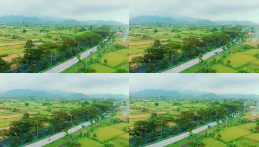 在印尼巴厘岛的阿米德，鸟瞰绿色的田野、绿色的大米和汽车行驶的道路高清在线视频素材下载