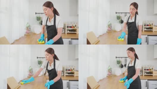 亚洲年轻清洁服务女工清洁厨房桌子在家里。年轻的女管家清洁工感到沮丧，而擦拭脏乱的烹饪柜台家务或杂务。高清在线视频素材下载