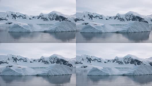 南极洲。南极洲雪山和冰雪海岸的景观。美丽的蓝色冰山与镜面反射漂浮在开放的海洋。严酷大陆上的冰川。高清在线视频素材下载