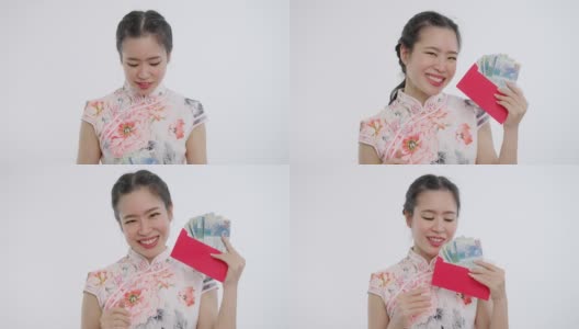 中国/亚洲妇女穿着旗袍，白色花卉图案的衣服，手里拿着红包送给她的家人、亲戚、后代和追随者，表示新年快乐、富裕、幸福和幸运高清在线视频素材下载