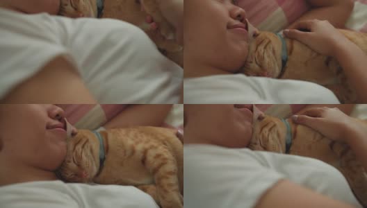 亚洲妇女睡觉和拥抱小猫小猫在家里的床上。高清在线视频素材下载