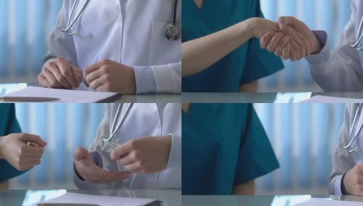医生给同事钞票并握手，这是非法协议高清在线视频素材下载