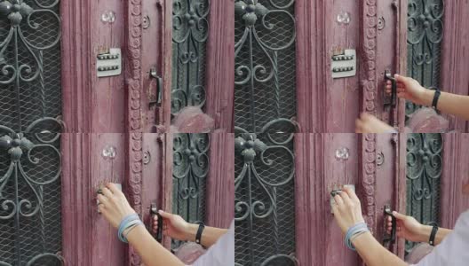 女性的手在用密码锁输入旧门上的密码高清在线视频素材下载