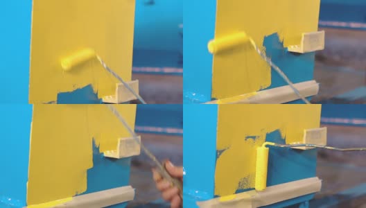 男子正在用手把蓝色的金属细节涂成黄色高清在线视频素材下载