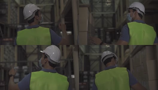 年轻的印度工厂仓库工人戴着防护面罩和安全帽在物流行业室内工作。30多名男子在检查新冠肺炎大流行期间的库存订单高清在线视频素材下载