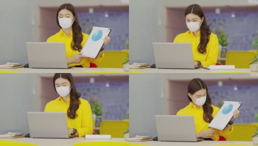 穿着黄色衬衫戴着外科口罩的亚洲女性的新常态通过VDO会议展示销售报告并在图中解释在现代办公室或联合办公空间创业高清在线视频素材下载