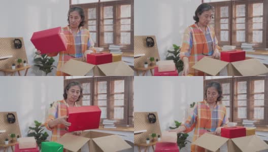 亚洲高级妇女打开纸板箱从网上购物和检查商品里面高清在线视频素材下载
