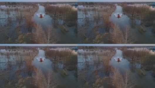 橙色的车在普里皮亚季河附近被洪水淹没的森林公路上。鸟瞰图。春天的时间。河洪水泛滥。高清在线视频素材下载