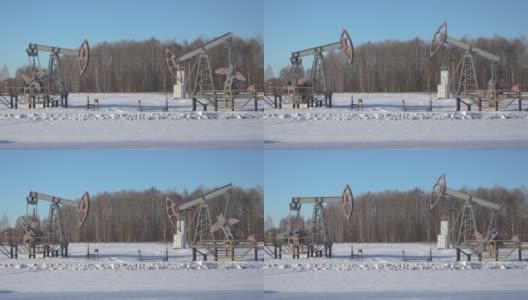 两个油泵在田野里，冬天雪花飘飘高清在线视频素材下载