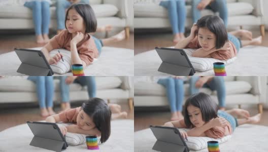 小女孩和父母坐在沙发上，在数码平板电脑上画画高清在线视频素材下载