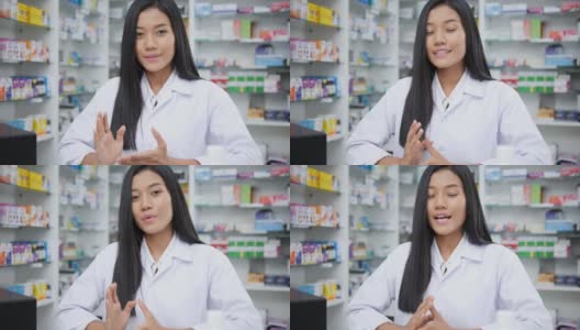女医生面试介绍和在药店工作。亚洲药剂师女孩建议在药店使用有药学背景的货架药品。看着镜头。高清在线视频素材下载