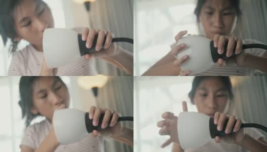 亚洲女孩在家组装从网上买的新电灯，女孩自己打结。高清在线视频素材下载