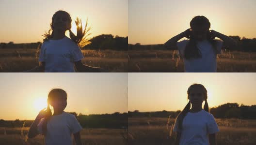 小女孩站在草地上，以夕阳为背景，对着相机微笑。快乐的小女孩玩她的头发休息在草地。自由自在的概念。多莉拍摄高清在线视频素材下载
