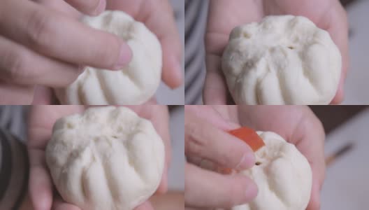 女厨师用手把腌过猪排的面团捏成小圆面包的形状，再在上面放上咸蛋黄。包子的制作过程。高清在线视频素材下载