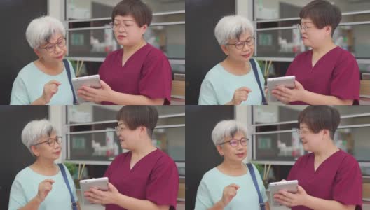 亚裔中国女护士在诊所用数码平板电脑向她的女病人解释体检报告高清在线视频素材下载