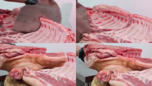 在肉类加工厂，屠夫用锋利的斧头劈生猪肉。高清在线视频素材下载